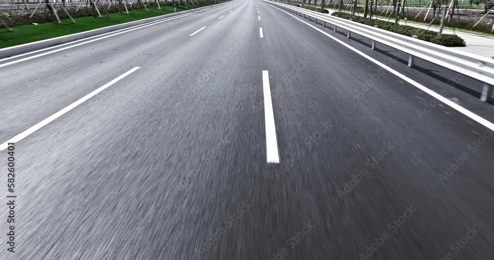 Close-up cinematic POV shot of an asphalt road. Car is driving on the highway. Close-up cinematic POV shot of an asphalt road. Car is driving on the highway.