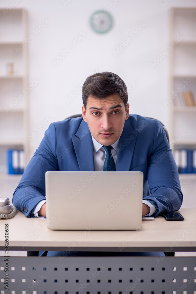 Young male employee working in the office Young male employee working in the office