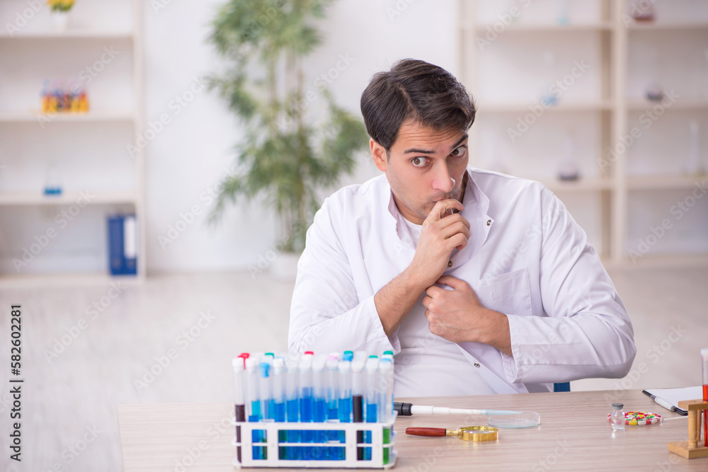 Young male chemist working at the lab Young male chemist working at the lab