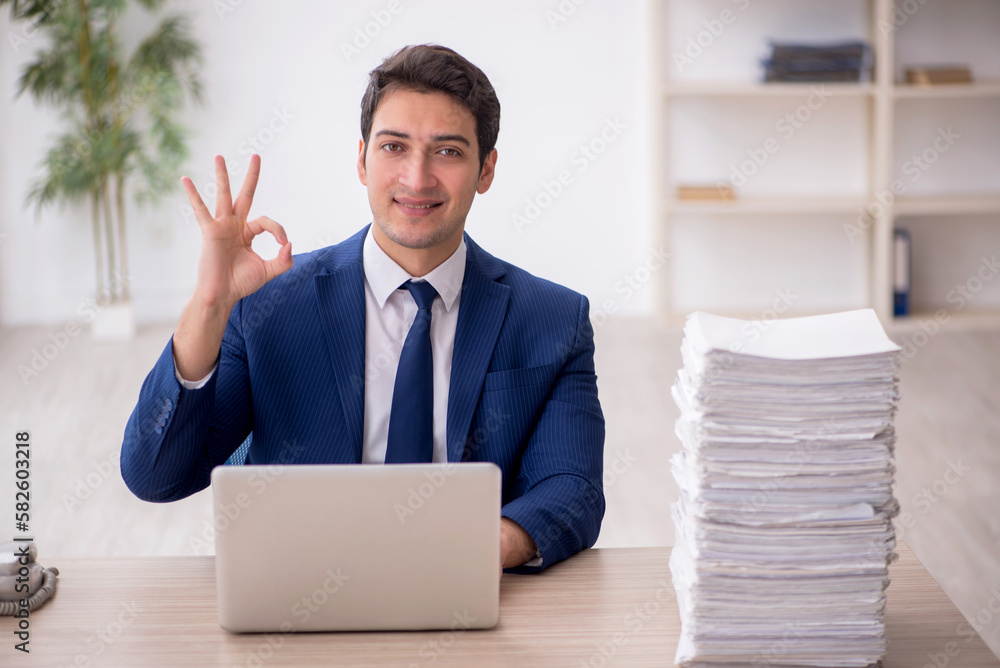 Young male employee and too much work in the office Young male employee and too much work in the office