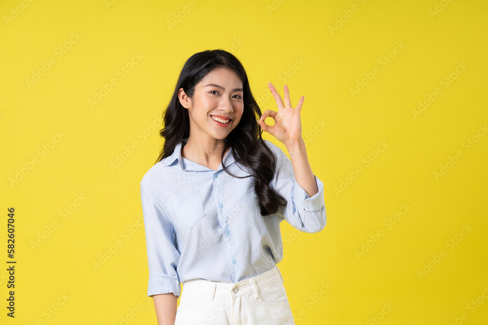 portrait of beautiful asian girl posing on yellow background portrait of beautiful asian girl posing on yellow background