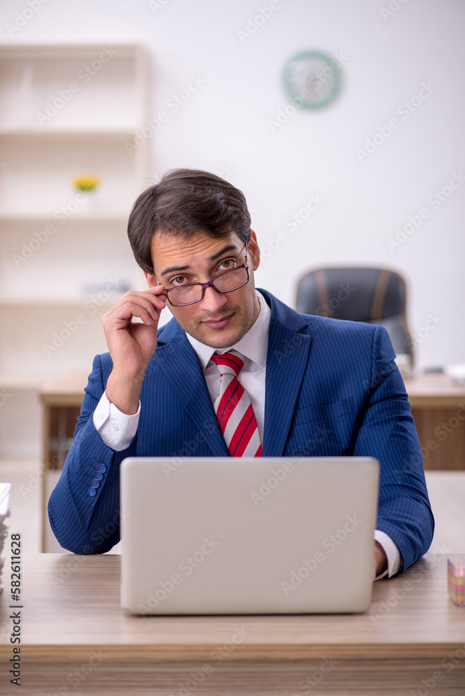 Young male employee and too much work in the office