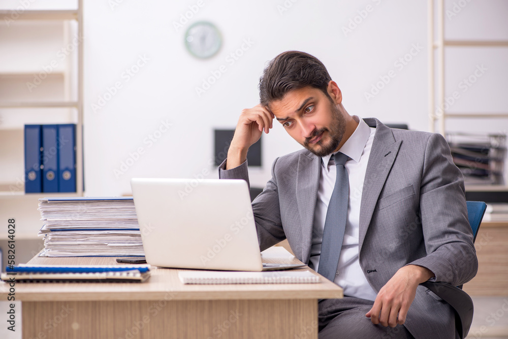 Young male employee working in the office Young male employee working in the office