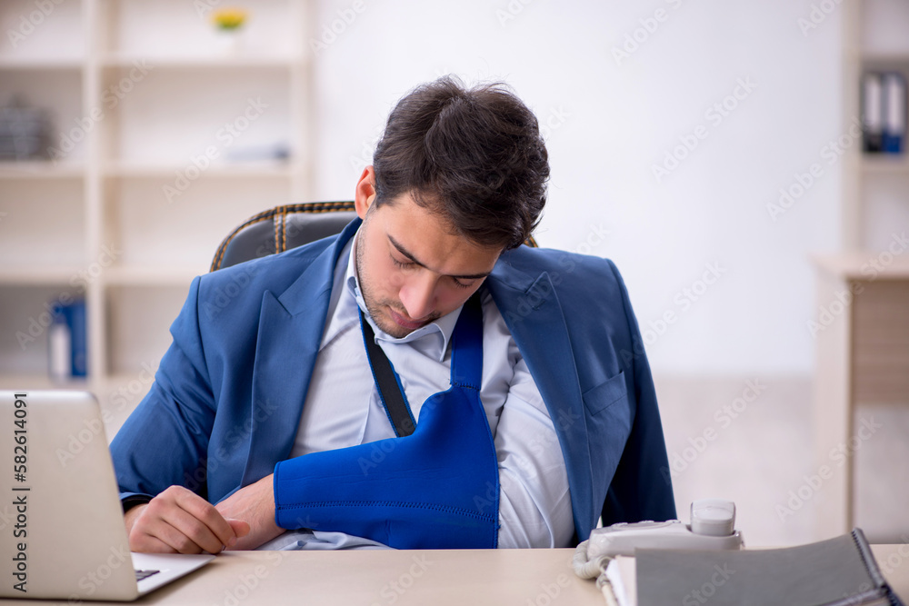 Young male employee after car accident at workplace