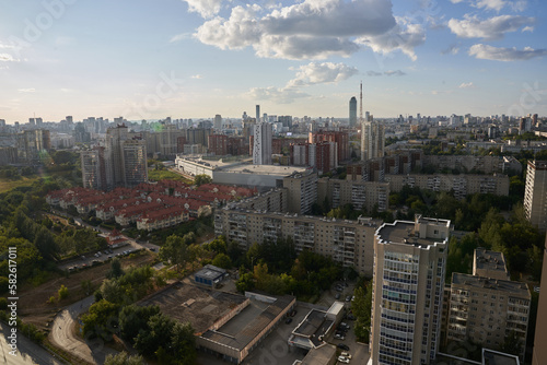 Apartment buildings in the background. Dense buildings of the city visible from above. Blue sky with clouds. RUSSIA - August 14, 2022, high-rise buildings from a height. High quality photo
