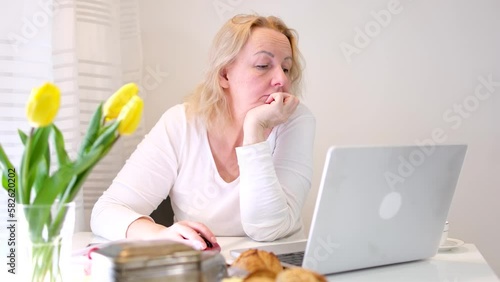 woman has been working in front of a computer monitor since the very morning Her eyes are tired rubbing eyes wake up there is no time to rest Yellow tulips breakfast on table tired eyes adulthood