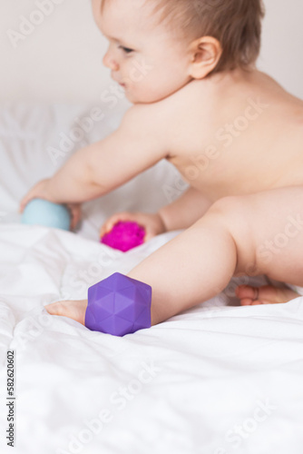 A toddler plays with rubber balls to develop motor skills and tactile sensations