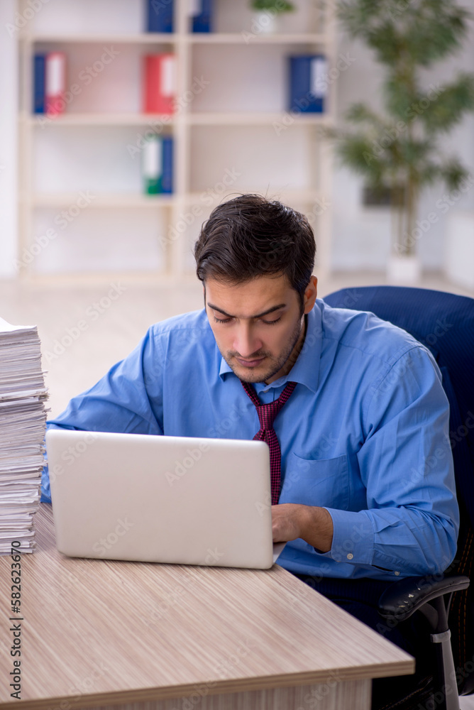 Fototapeta premium Young male employee and too much work in the office
