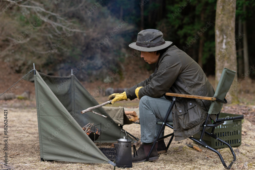 Obraz premium ソロキャンプで焚き火をする男性
