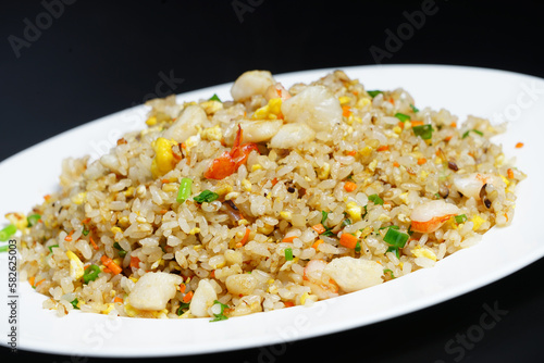 A plate of seafood scary Yangzhou fried rice on black background