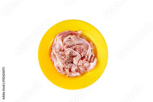 Fresh chicken meat, topped with white sesame seeds, placed on a plate, top view