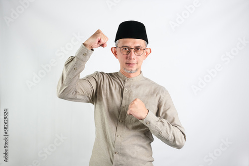 Portrait of Asian Moslem Man with a spirited expression ,celebrating success isolated over white background.

