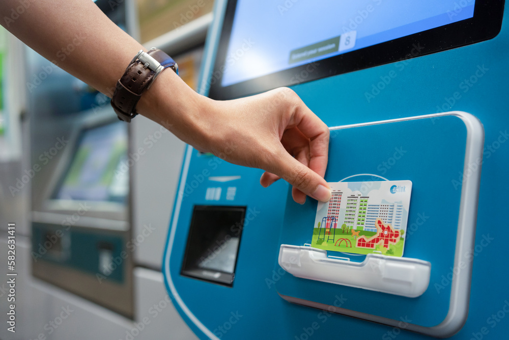 SINGAPORE APR 19, 2022 Lady's hand placing the Singapore MRT Card