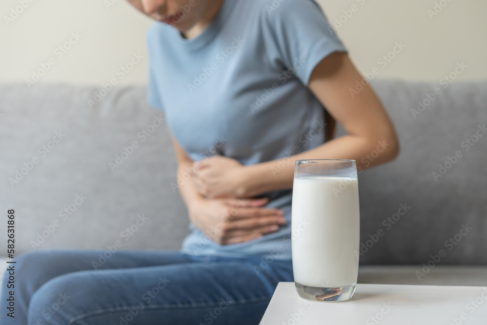 Pain, suffering asian young woman having a stomachache, abdominal pain or digestive, hand in