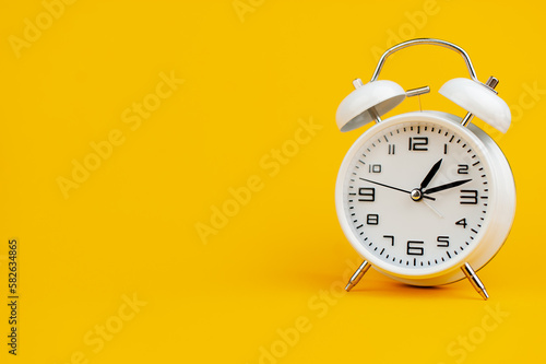 white clock on yellow background concept of time time is important to work