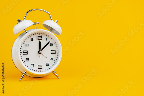 white clock on yellow background concept of time time is important to work