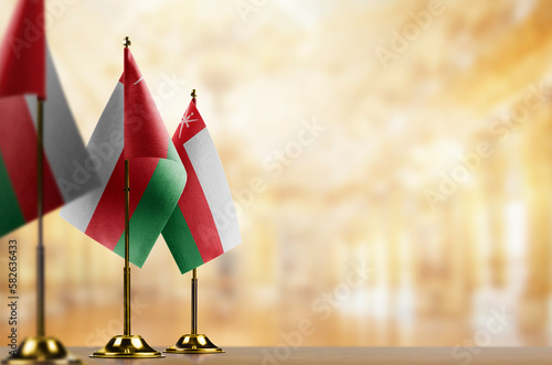 Small flags of the Oman on an abstract blurry background