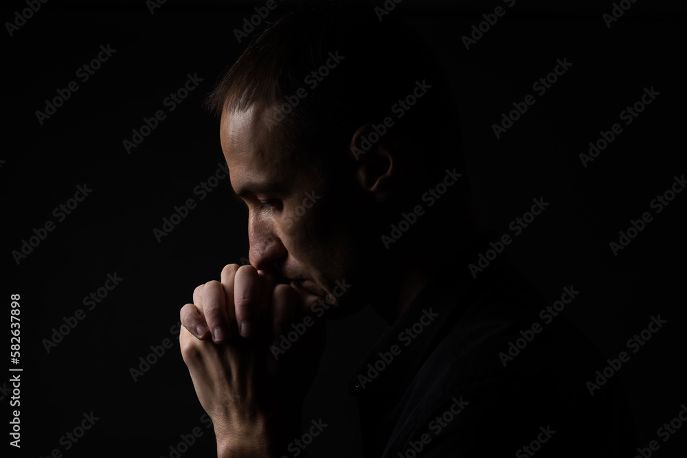 Portrait of a handsome man praying over gray background