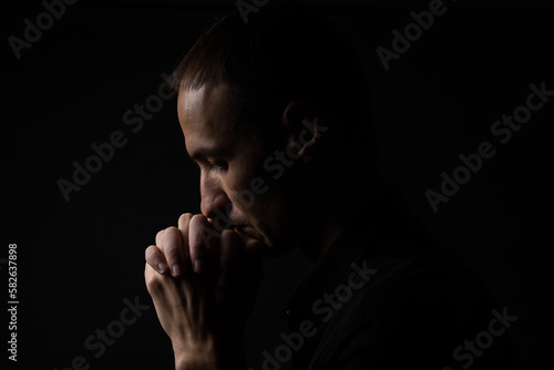 Portrait of a handsome man praying over gray background