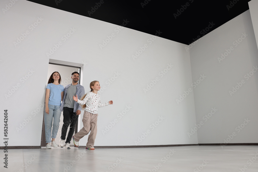 Happy family entering in their new apartment on moving day, low angle view. Space for text Happy family entering in their new apartment on moving day, low angle view. Space for text