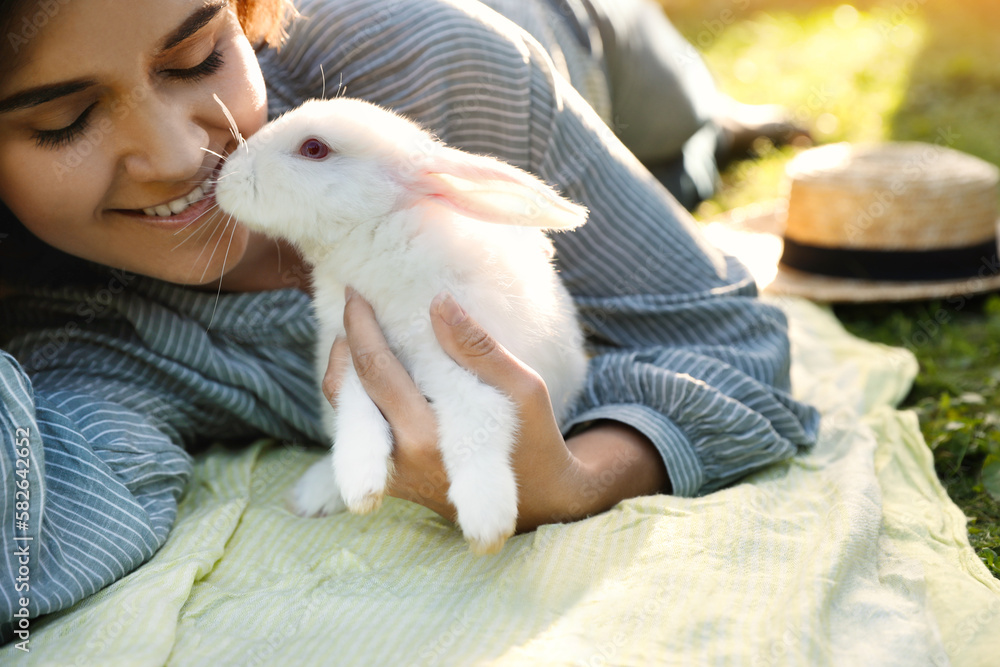 Happy woman with cute rabbit on green grass outdoors, closeup Happy woman with cute rabbit on green grass outdoors, closeup