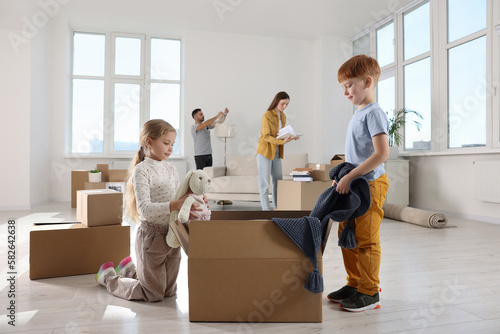 Obraz na plátně Happy family settling into new house and unpacking boxes