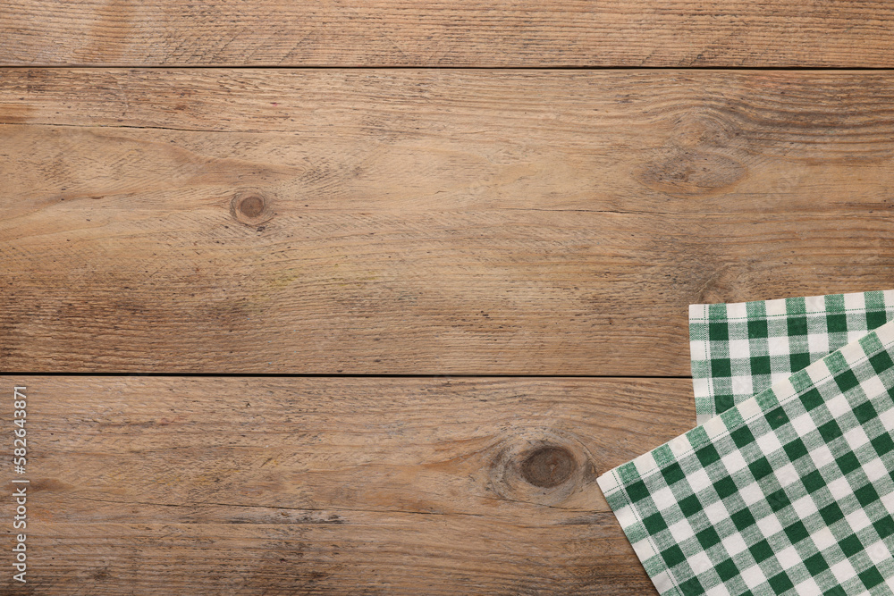 Checkered tablecloth on wooden table, top view. Space for text Checkered tablecloth on wooden table, top view. Space for text