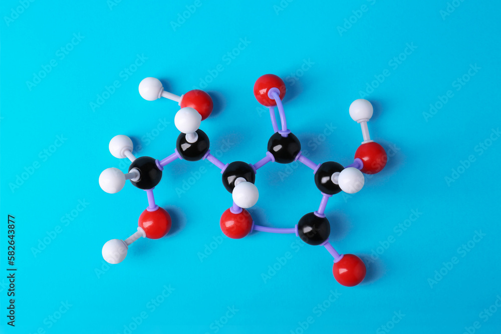 Molecule of vitamin C on light blue background, top view. Chemical model