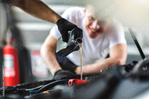 Pouring oil to car engine. Closue up male mechanic hand working  and service in Car Service station © NVB Stocker