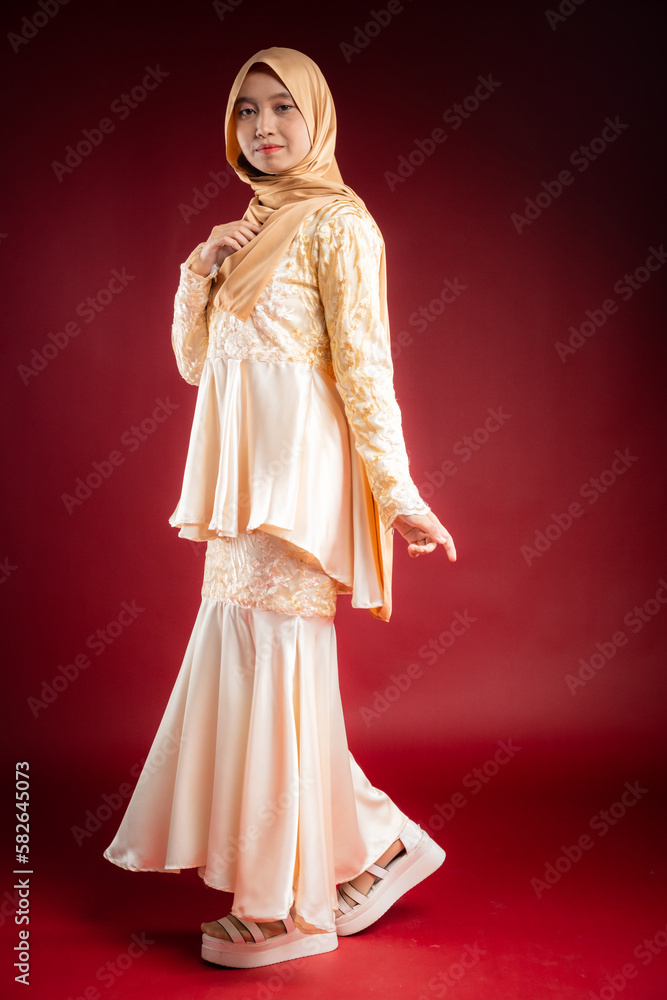 Portrait of a beautiful Asian Muslim female model wearing hijabwear with at a studio photoshoot. Modern hijab fashion and beauty concept Portrait of a beautiful Asian Muslim female model wearing hijabwear with at a studio photoshoot. Modern hijab fashion and beauty concept