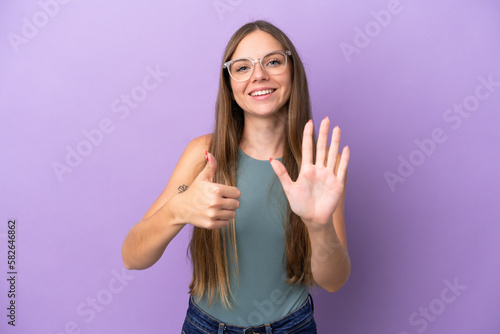 Young Lithuanian woman isolated on purple background counting six with fingers