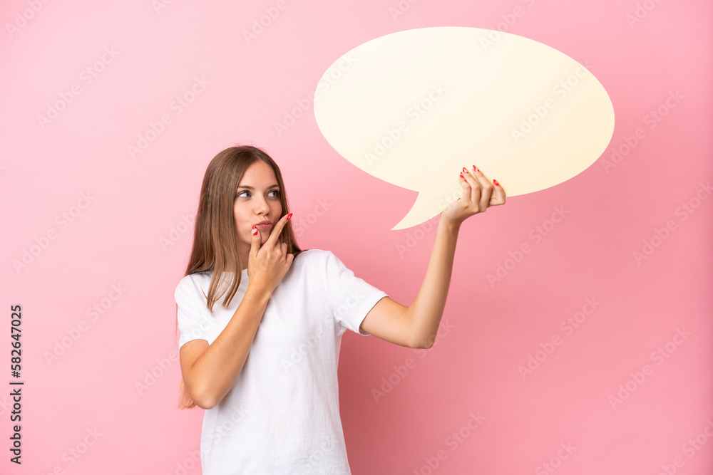 Young Lithuanian woman isolated on pink background holding an empty speech bubble and thinking Young Lithuanian woman isolated on pink background holding an empty speech bubble and thinking
