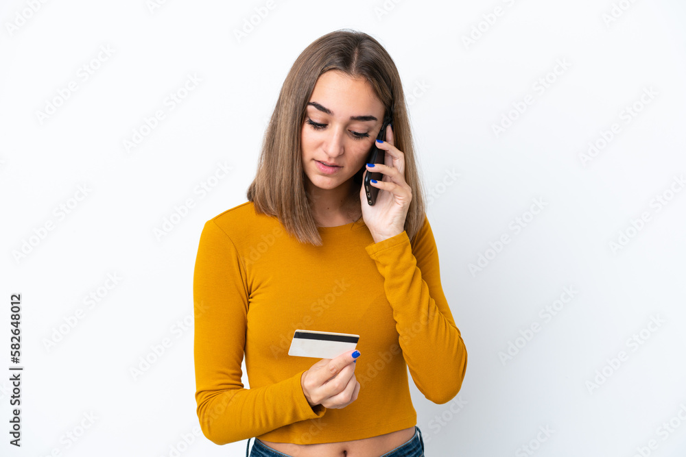 Young caucasian woman isolated on white background buying with the mobile with a credit card Young caucasian woman isolated on white background buying with the mobile with a credit card