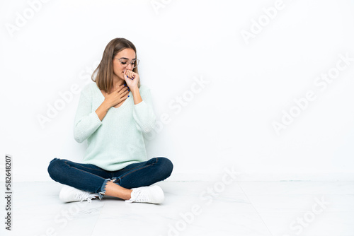 Young caucasian woman sitting on the floor isolated on white background is suffering with cough and feeling bad