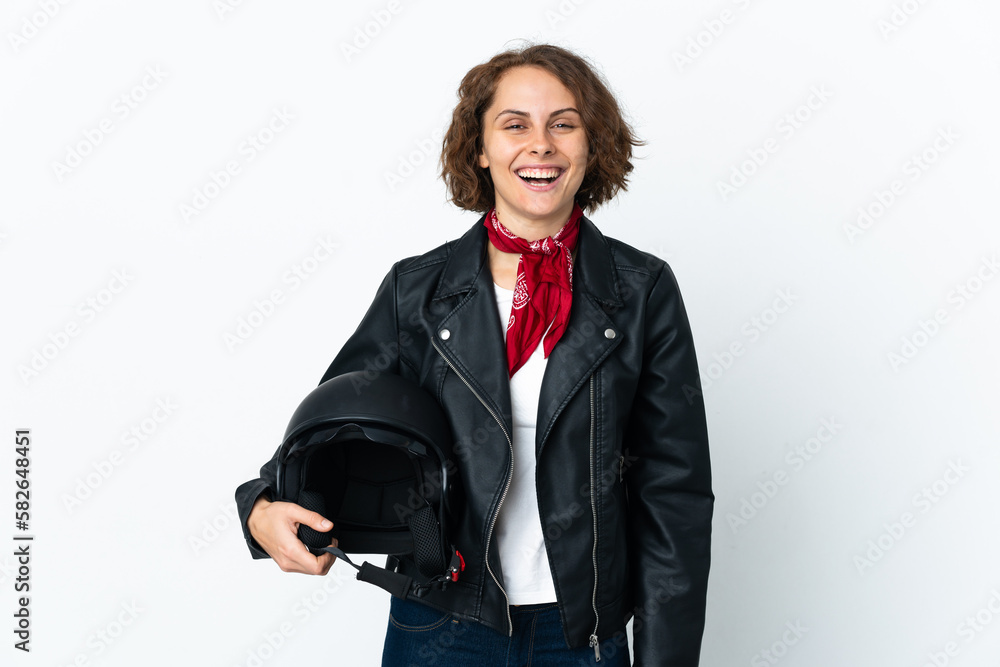 English woman holding a motorcycle helmet isolated on white background with surprise facial expression English woman holding a motorcycle helmet isolated on white background with surprise facial expression