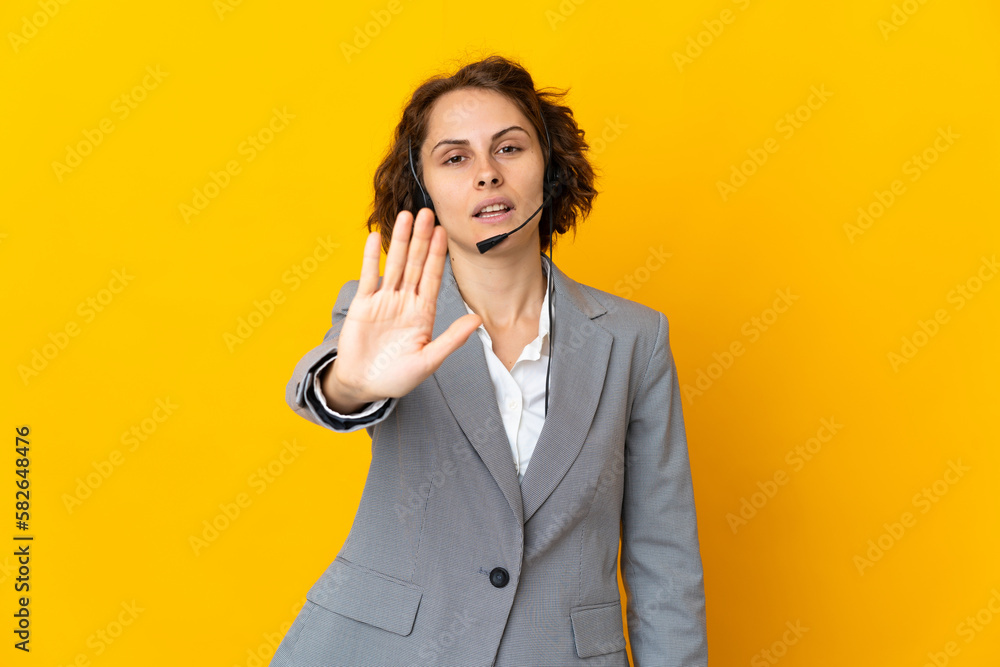 Young English woman isolated on yellow background making stop gesture Young English woman isolated on yellow background making stop gesture