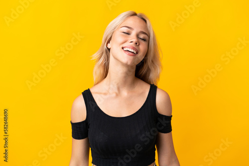 Young Russian woman isolated on yellow background laughing