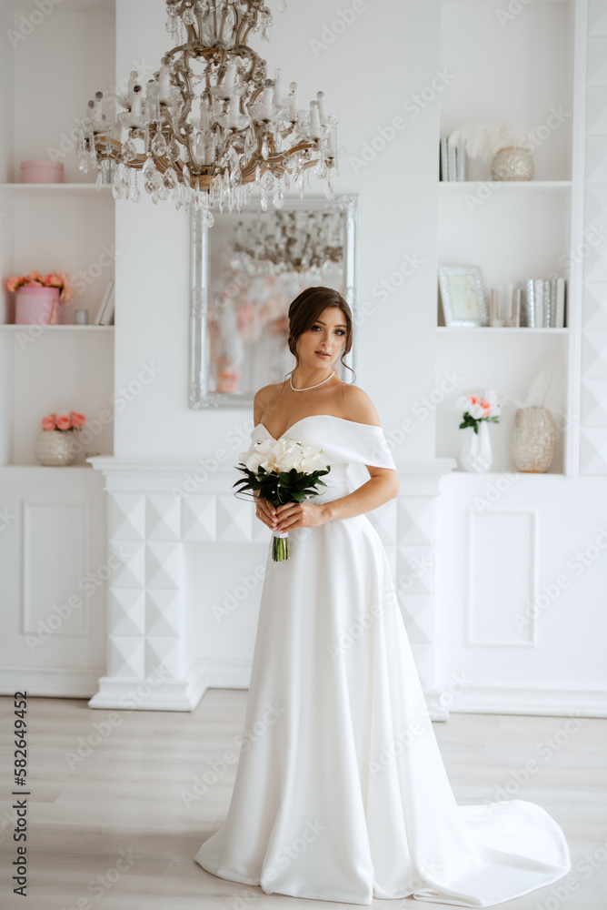brunette bride in a tight wedding dress in a bright studio brunette bride in a tight wedding dress in a bright studio
