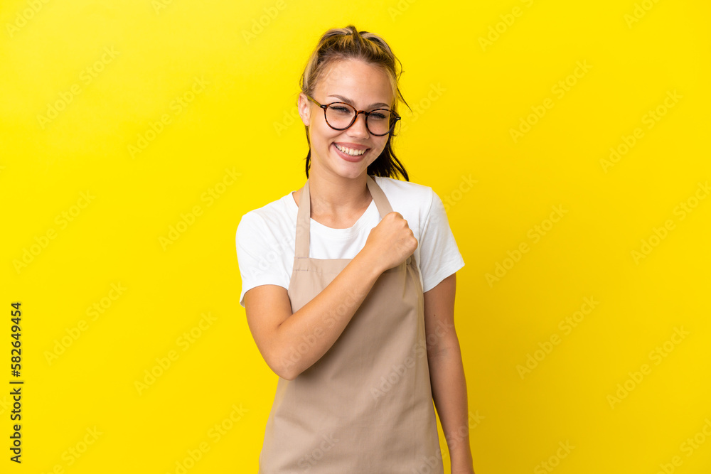 Restaurant waiter Russian girl isolated on yellow background celebrating a victory Restaurant waiter Russian girl isolated on yellow background celebrating a victory