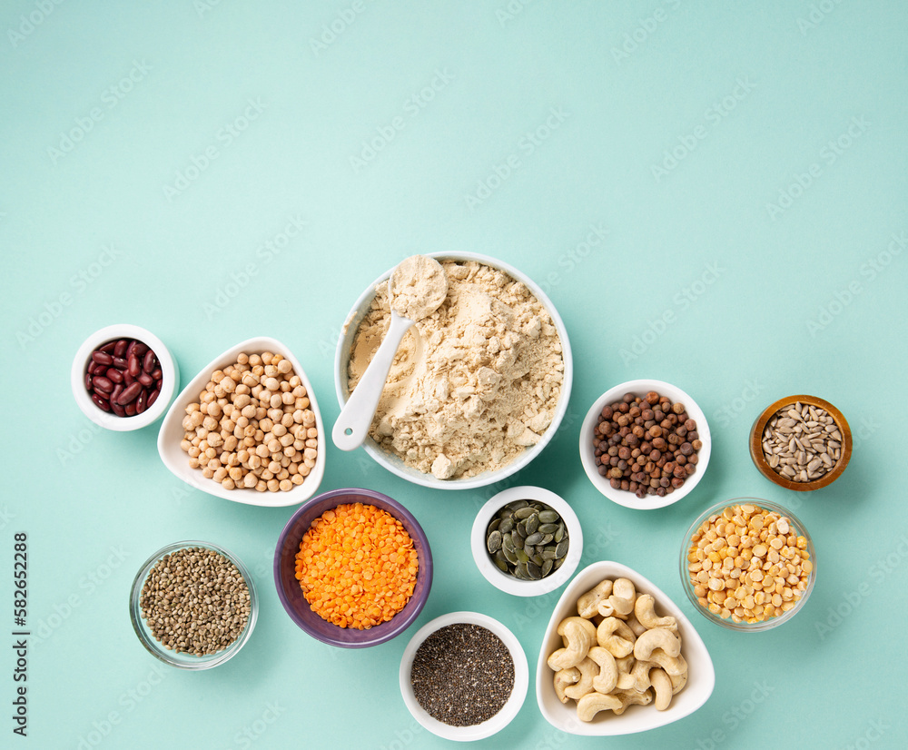 Healthy Dry Pea Protein Powder and Plant Based Protein Food (legumes, lentils, beans, seeds) on Blue Green Background. Healthy Dry Pea Protein Powder and Plant Based Protein Food (legumes, lentils, beans, seeds) on Blue Green Background.