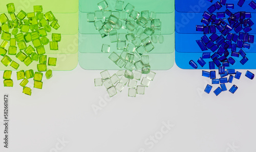 colored transparent plastic resin granulates with color sample plates in laboratory