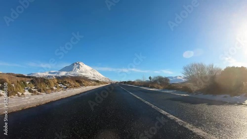 Driving on the R251 towards the snow covered Mount Errigal, the highest mountain in Donegal - Ireland. photo