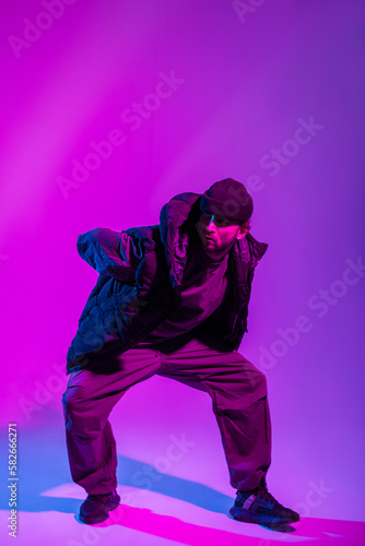 Professional dancer guy in fashionable clothes dancing in a colorful creative studio