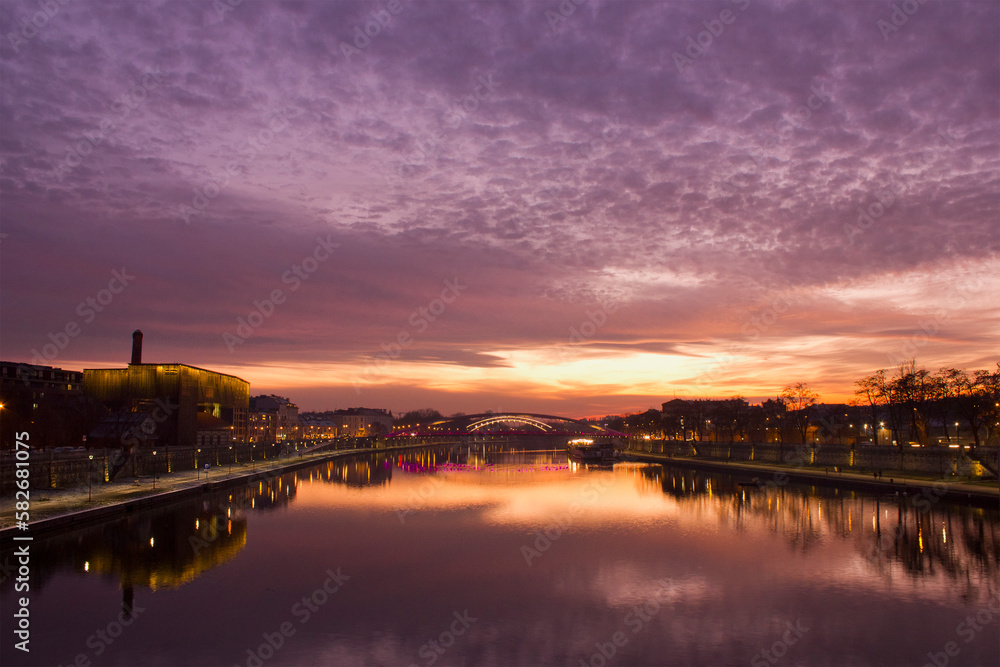 a purple sunset over the Vistula in Krakow.  Cityscape with river, bridge and evening lights