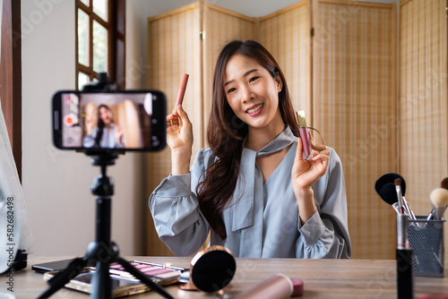 Beauty blogger, young asian woman, girl vlogger posting, showing, reviews cosmetics products while recording video, tutorial to share on social media. Business online influencer on smartphone