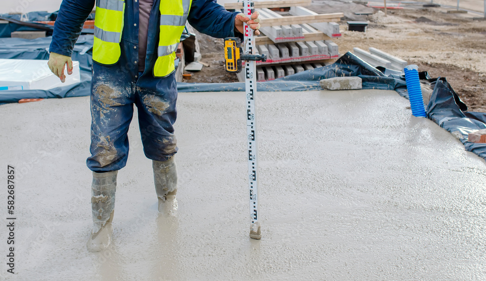 Slab Level Set Builder pouring ground floor slab of a new house with wet ready-mix ...