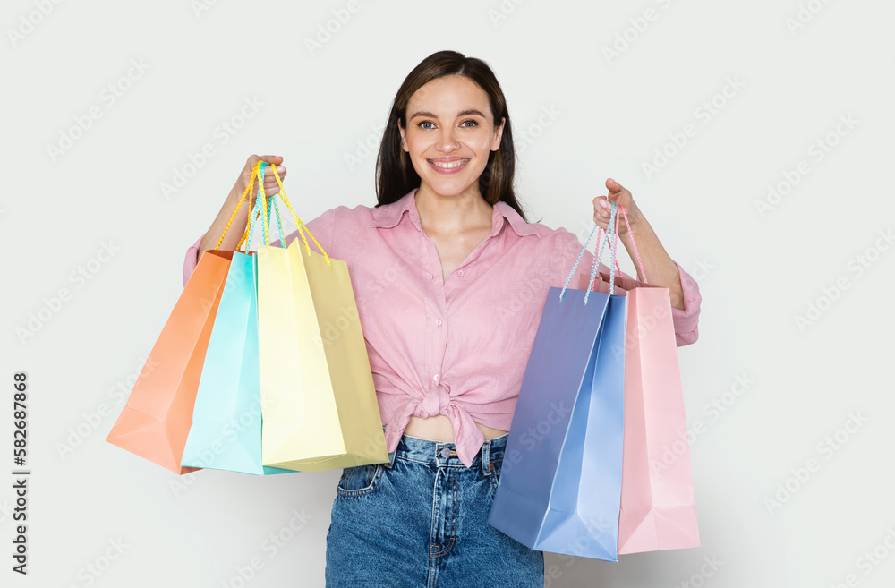 Happy pretty young woman holding colorful shopping bags, shopping concept