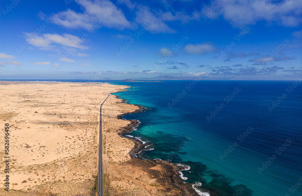 Aerial high level panoramic view of the sand dunes and road between the coast and Parque Natural sand dunes heading to Corralejo Fuerteventura Spain