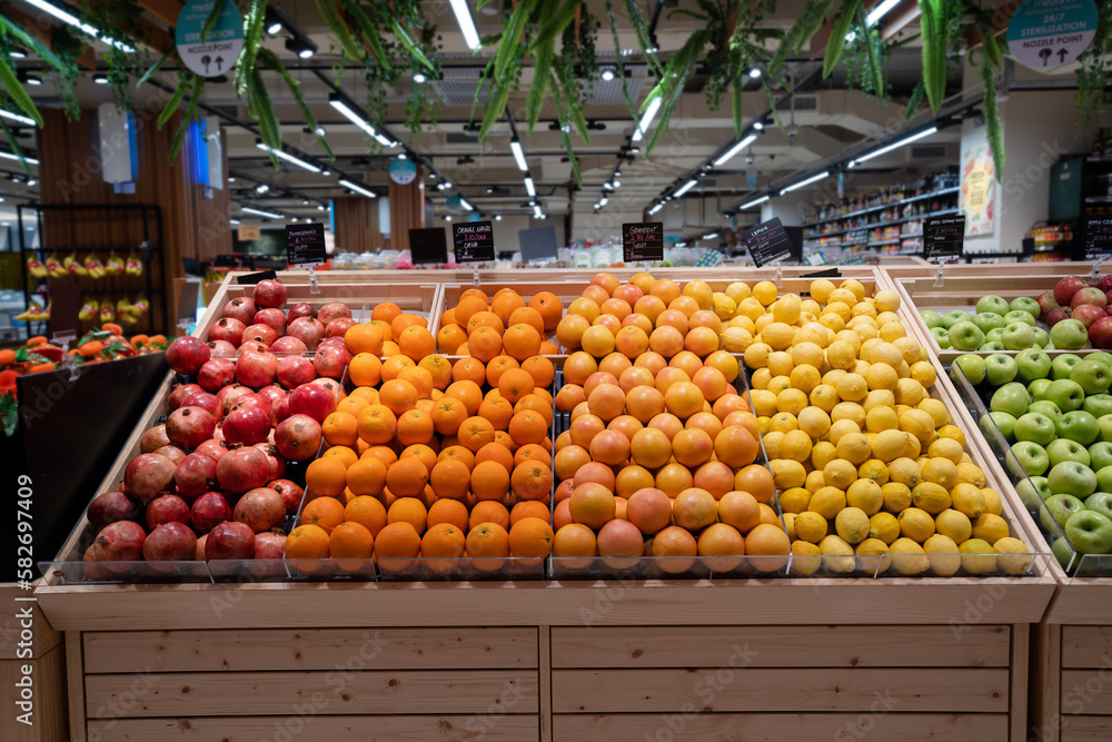 Various type of fresh fruits arrange neatly grocery store. Apple, Orange, Pomegranate, Lemon on rack.