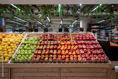 Various type of fresh fruits arrange neatly grocery store. Apple, Orange, Pomegranate, Lemon on rack.